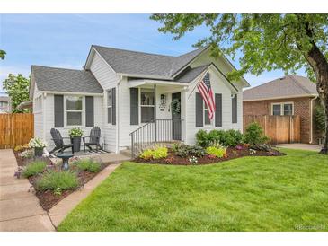 Charming home with a well-manicured front yard, black shutters and chairs, and an American flag at 2212 Ingalls St, Edgewater, CO 80214