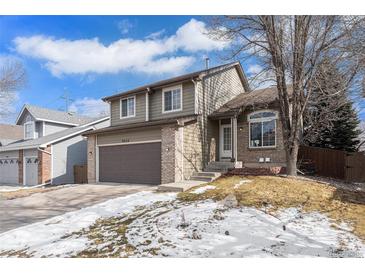 Charming two-story home with brick accents, attached two car garage, and landscaped front yard at 9314 Wiltshire Dr, Highlands Ranch, CO 80130