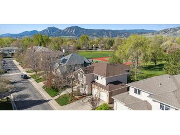 Aerial view of a two-story home with a two car garage, lush landscaping, and mountain views in the background at 4059 Nevis St, Boulder, CO 80301