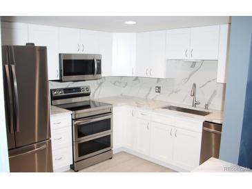 Modern kitchen featuring stainless steel appliances, sleek countertops, and bright white cabinetry at 14300 E Marina Dr # 109, Aurora, CO 80014