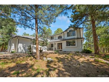 Beautiful two-story home featuring a modern design and situated in a serene wooded setting at 1935 Poncha Ct, Larkspur, CO 80118