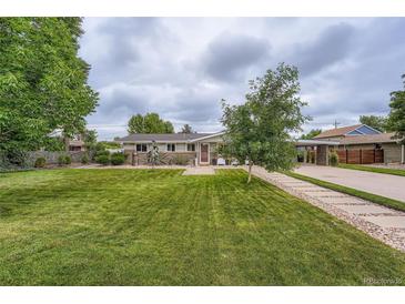 Charming single-story home with a well-manicured lawn, beautiful landscaping, and a welcoming entrance at 8455 W Belmar Ave, Lakewood, CO 80226