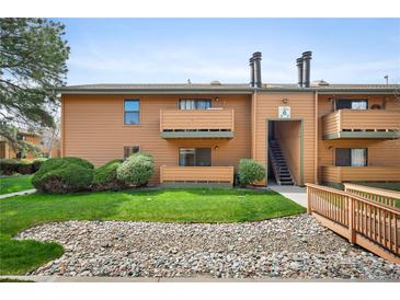 Inviting condo exterior with maintained landscape, balconies, and staircase leading to the building's entrance at 3335 S Ammons St # 6-102, Lakewood, CO 80227