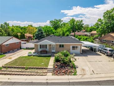 Charming single-story home with a well-maintained front yard and a convenient carport on a sunny day at 10951 Rosalie Dr, Northglenn, CO 80233