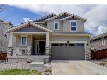 Charming two-story home with a covered porch, stone accents, and a two-car garage on a sunny day at 1246 Blackhaw St, Elizabeth, CO 80107
