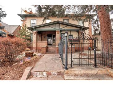 Brick two-story home with a stone path, wrought-iron fence, and landscaping at 471 N Humboldt St, Denver, CO 80218