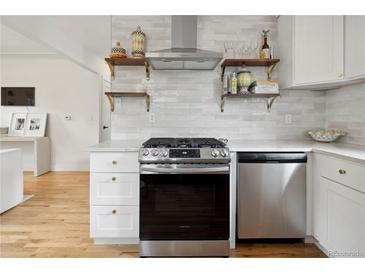 Modern kitchen features stainless steel appliances, white cabinets, and open shelving at 4419 W 34Th Ave, Denver, CO 80212