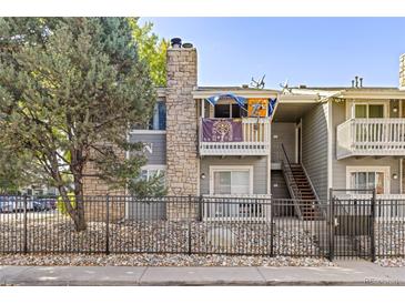 Exterior view of a condo building with a stone facade and a private balcony at 4400 S Quebec St # 204N, Denver, CO 80237