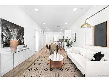 Spacious living room with a large rug, contemporary decor, and lots of natural light throughout the home at 2851 W 52Nd Ave # 304, Denver, CO 80221