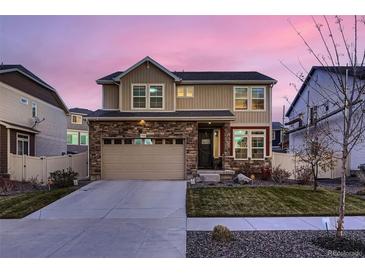 Charming two-story home with a stone facade, manicured lawn, and a spacious two-car garage at 4526 N Quatar Ct, Aurora, CO 80019