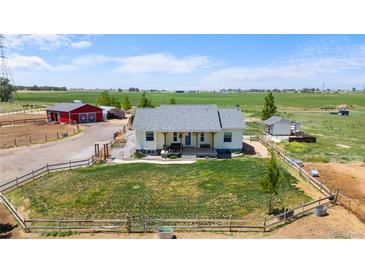 Charming home on a vast lot featuring a large front yard, red barn, and scenic countryside views at 10691 County Road 23, Fort Lupton, CO 80621