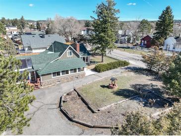 Charming home with lush green yard, water well feature, mature trees, and beautiful stone accents at 335 Jefferson St, Monument, CO 80132