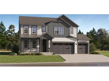 Two-story house with gray and white siding, two-car garage, and landscaping at 908 Congress Pl, Elizabeth, CO 80107