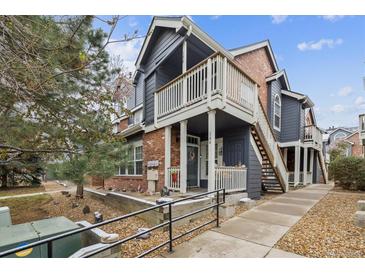 Charming townhome features brick accents, a cozy entryway, and a second-story balcony at 14399 E Grand Dr # 150, Aurora, CO 80015