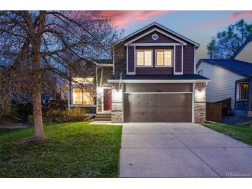 Two-story home with a two-car garage, complemented by a well-manicured lawn and attractive landscaping at 2574 Cove Creek Ct, Highlands Ranch, CO 80129