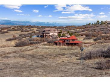 Expansive aerial view of the luxury home and its surroundings, featuring rolling hills and mountain views at 2505 Big Bear Cir, Sedalia, CO 80135