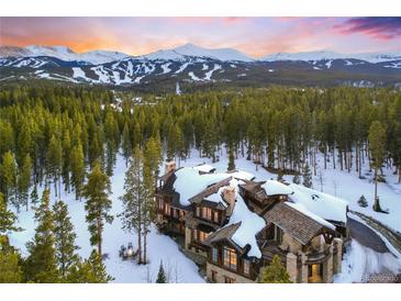 A stunning snow-covered home with mountain views and lush green trees at 327 Peerless Dr, Breckenridge, CO 80424