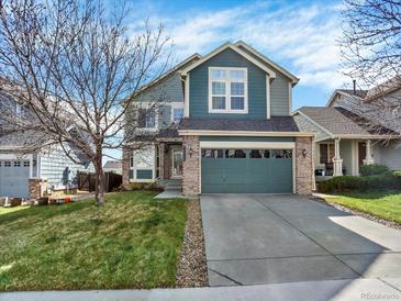 Inviting two-story home featuring a two-car garage, brick accents, and a well-maintained lawn at 8380 Blackgum St, Parker, CO 80134