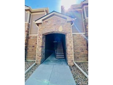 Welcoming stone entrance with a staircase, creating an inviting first impression of the property at 7440 S Blackhawk St # 207, Englewood, CO 80112