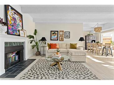 Bright living room features a comfortable sectional sofa, a fireplace, and stylish decor at 7877 E Mississippi Ave # 604, Denver, CO 80247