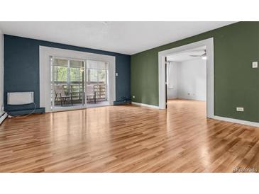 Open floor plan featuring living room, balcony access, and hardwood floors at 705 S Alton Way # 6B, Denver, CO 80247
