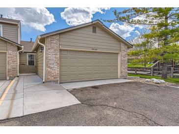 Attached two-car garage with brick accents and a concrete driveway at 10510 W Fair Ave # A, Littleton, CO 80127