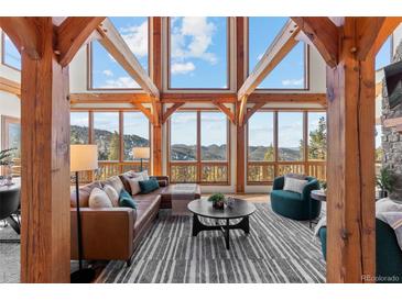 Spacious living room boasts stunning mountain views & high ceilings at 13326 Kuehster Rd, Littleton, CO 80127