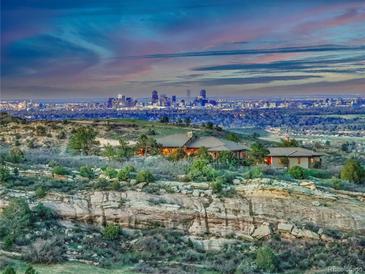 Stunning aerial view of the estate at dusk with city skyline in the background at 15175 W Belleview Ave, Morrison, CO 80465