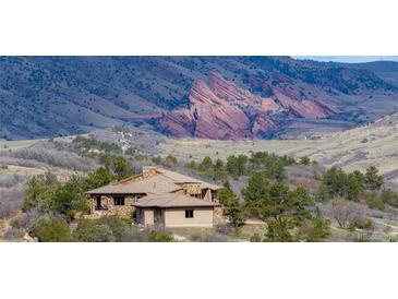 Exterior of home with tile roof nestled among trees and rolling hills, offering a peaceful retreat with scenic views at 15175 W Belleview Ave, Morrison, CO 80465