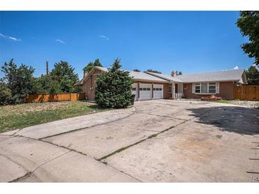 A charming brick home with a spacious driveway and a well-manicured lawn and a two car garage at 3306 S Uinta Ct, Denver, CO 80231
