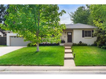 Charming one-story home featuring a lush green lawn and a classic painted brick exterior at 801 S Harrison St, Denver, CO 80209