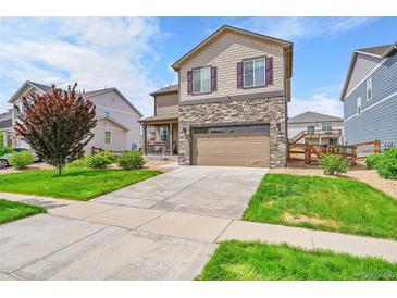 Two story home featuring a stone facade and manicured lawn at 7465 E 157Th Pl, Thornton, CO 80602