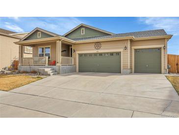 Charming ranch-style home featuring a covered front porch and a two-car garage at 9868 Olathe St, Commerce City, CO 80022