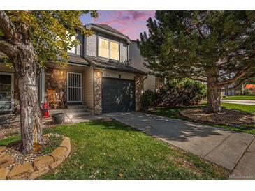 Charming two-story home features a well-manicured lawn and stone accents at 2215 E 103Rd Pl, Thornton, CO 80229