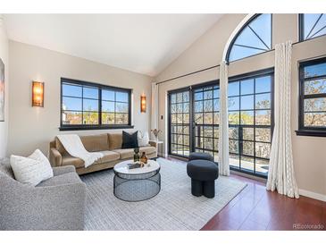 Bright living room featuring large windows, vaulted ceilings, modern furnishings and hardwood floors at 345 Fillmore St # 409, Denver, CO 80206