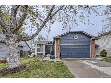 Charming blue home with a two-car garage, brick accents, and a well-maintained lawn at 5550 E 130Th Dr, Thornton, CO 80241