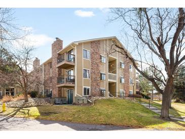 Multi-story condo building featuring brick and siding, balconies, and professionally landscaped grounds at 3041 S Ursula Cir # 302, Aurora, CO 80014