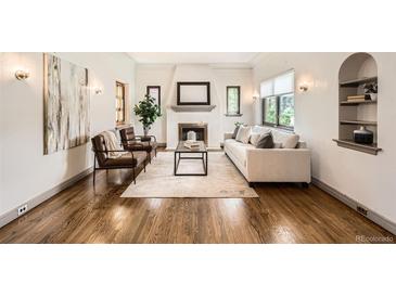Inviting living room showcasing a fireplace, hardwood floors, and ample natural light at 1418 Glencoe St, Denver, CO 80220