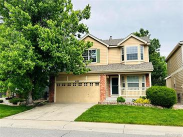 Inviting two-story home with a well-manicured lawn, mature shade tree, and attached two car garage at 6102 S Yampa St, Aurora, CO 80016
