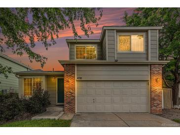Charming two-story home with brick accents, attached garage, and beautiful sunset backdrop at 4710 N Foxtail Dr, Castle Rock, CO 80109