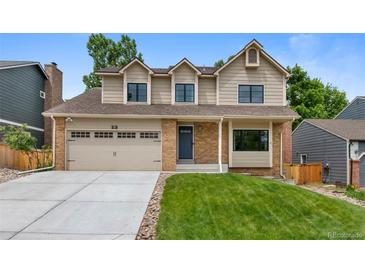 Charming two-story home featuring a brick and siding facade, well-manicured lawn, and a convenient two-car garage at 23 Honey Locust, Littleton, CO 80127