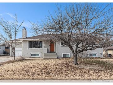 Ranch style home with a brick facade, mature trees, and a spacious yard at 4675 Reed St, Wheat Ridge, CO 80033