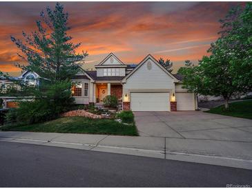 Charming two-story home with a well-manicured lawn, a three car garage and lush landscaping at 848 Huntington Pl, Highlands Ranch, CO 80126