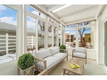 Bright sunroom featuring large windows, comfortable seating, and a view of the outdoors at 655 S Clinton St # 2A, Denver, CO 80247