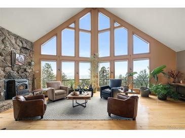 Bright living room with vaulted ceilings, large windows and mountain views at 13452 Riley Peak Rd, Conifer, CO 80433