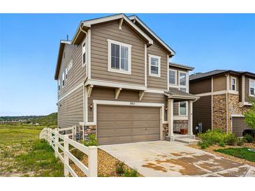 Two-story home with a two-car garage, neutral siding, and a well-maintained front yard with a white picket fence at 2511 Loon Ln, Castle Rock, CO 80104