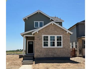 Charming two-story home with a combination of stone and siding exterior and a welcoming front porch at 3295 N Coolidge Way, Aurora, CO 80019