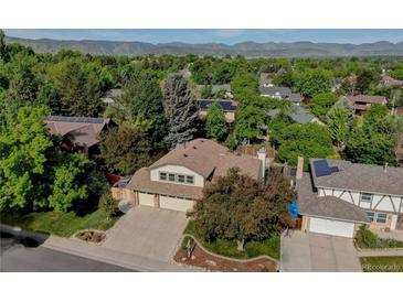 Beautiful home with a two car garage, mature trees and solar panels, with mountain views in the background at 8043 S Zephyr St, Littleton, CO 80128