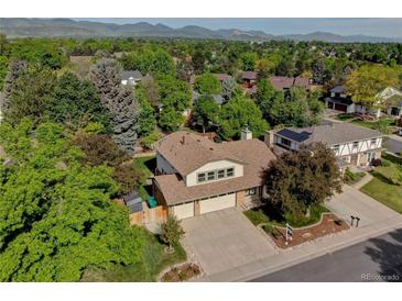 Inviting two-story home with a three-car garage, lush trees, and mountain views at 8043 S Zephyr St, Littleton, CO 80128