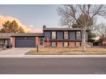 Charming two-story home with brick accents, complemented by a well-manicured front yard and mature tree at 18200 E Asbury Pl, Aurora, CO 80013